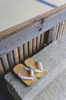 Geta or traditional Japanese footwear, a kind of flip-flops or sandal with an elevated wooden base held onto the foot with a fabric thong strap clipart