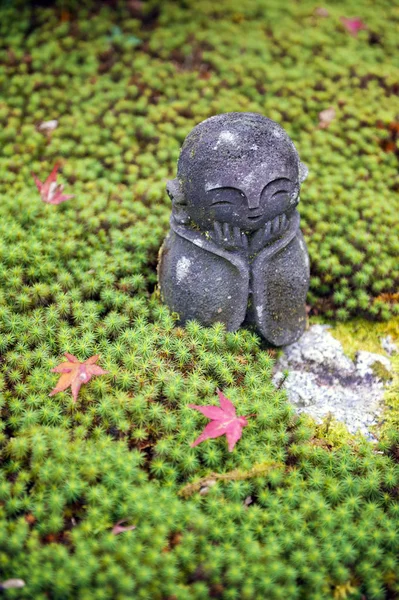 Stone statue of Jizo on ground covered by green star moss and red maple leaves during autumn in a garden at Enkoji temple in Kyoto, Japan — Stock Photo, Image