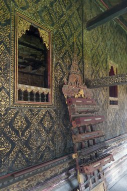 : Yasothon, Thailand - Mayıs 2017: Tay stilinde dekore pencere ve oyma ahşap raf Ho Trai veya Wat Mahathat Tapınağı'nda bulunan Tripitaka (Pali Canon) Kütüphanesi içinde kutsal kutulu yaldızlı duvar