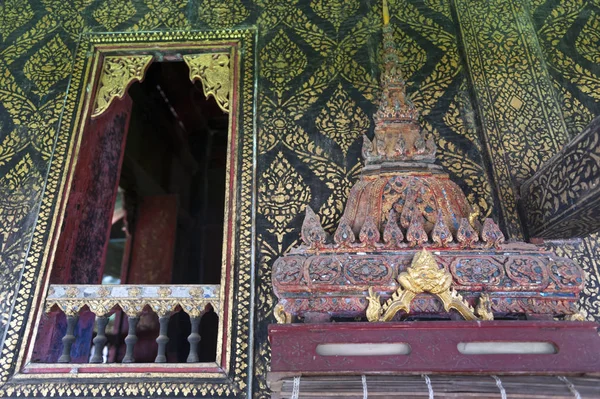 Yasothon, Thaïlande - Mai 2017 : Fenêtre décorée de style thaï et mur doré, avec boîte à écritures sur une étagère en bois sculpté à l'intérieur de Ho Trai ou la bibliothèque de Tripitaka (Canon Pali) située au temple Wat Mahathat — Photo