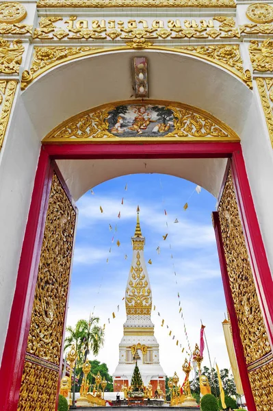 Huvudsakliga dörröppningen till buddhistiska templet av Wat Phra That Phanom hus berömda stupa som innehåller Buddhas bröstbenet i Nakhon Phanom Province, nordöstra Thailand. Thailändska texter skrivna ovan portvalvet är namnet på templet. — Stockfoto