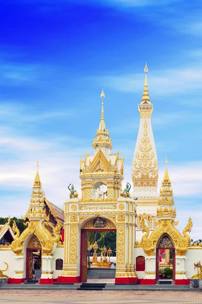 Huvudsakliga dörröppningen till buddhistiska templet av Wat Phra That Phanom hus berömda stupa som innehåller Buddhas bröstbenet i Nakhon Phanom Province, nordöstra Thailand. Thailändska texter skrivna ovan portvalvet är namnet på templet. — Stockfoto