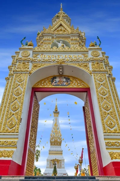 Hovedinngangen til det buddhistiske tempelet i Wat Phra At Fanom huser berømte stupa som inneholder Buddhas brystbein i Nakhon Phanom-provinsen, nordøst i Thailand. Thailandske tekster skrevet over buegangen er navnet på tempelet . – stockfoto
