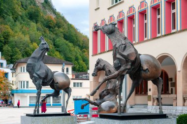 Vaduz, Liechtenstein - October 2019: Bronze sculptures named Tre Cavalli, The Three Horses, by Swiss artist, Nag Arnoldi, installed at Vaduz town hall clipart
