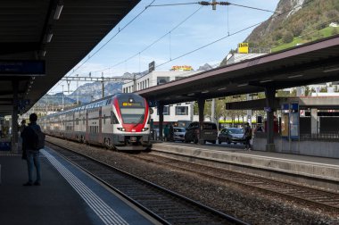 Sargans, İsviçre - Ekim 2019: İsviçre 'deki Sargans Tren Garı' na gelen RegioExpress treni arka plandaki Gonzen zirvesinin bir görüntüsü