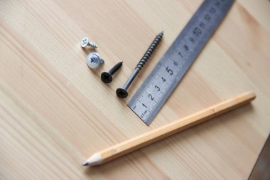 Çalışma süreci. Vidalar, cetvel, kalem.