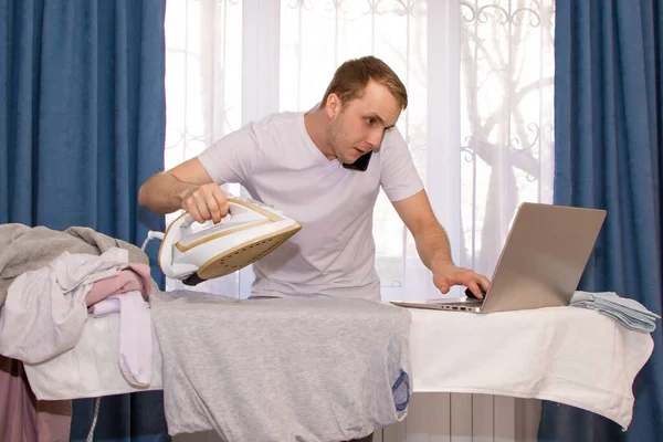 a young guy at home on self-isolation works remotely and is engaged in ironing.