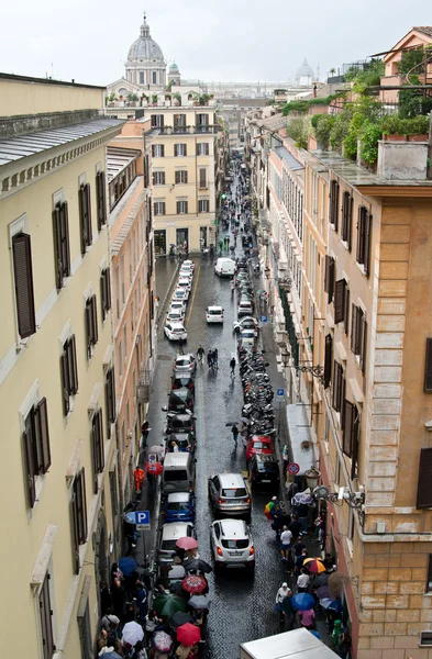 Rua estreita italiana que leva à Basílica de São Pedro. Na rua um monte de carros e pessoas sob guarda-chuvas. — Fotografia de Stock