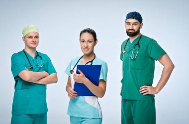 Üç genç doktorlardan oluşan bir ekip. Takım dahil bir doktor ve bir kadın, iki erkek doktorlar. Onlar içinde scrubs giyindin. Kız önünde ayakta ve tablet ve erkekler vardır arkasında tutar.