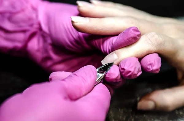 O processo de corte da cutícula usando pinças para manicure . — Fotografia de Stock