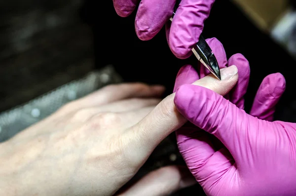 Proces usuwania skórek przy użyciu pęsety do manicure. — Zdjęcie stockowe