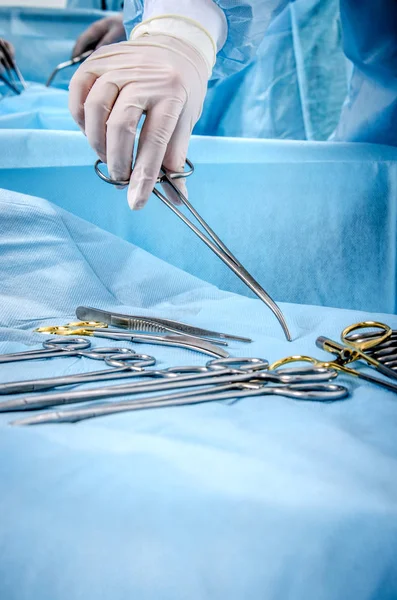 Hermana operadora lleva al clip de la mesa de operaciones durante la cirugía . — Foto de Stock