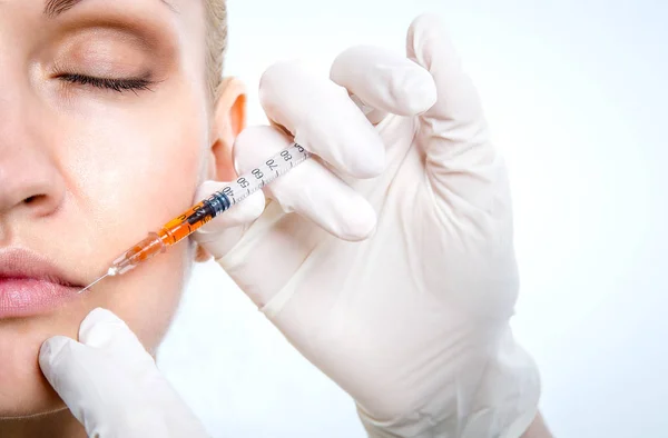 Az orvos a fehér latex Védőkesztyűk teszi a beteg az injekciót az ajkak. — Stock Fotó