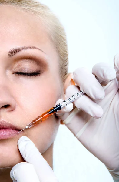 El médico con guantes protectores de látex hace que el paciente se inyecte en los labios . — Foto de Stock