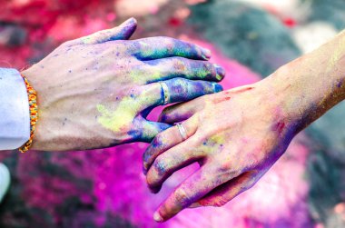 İki eli, boya ile Holi lekeli. Aday parmak alyans giyiyorsun.