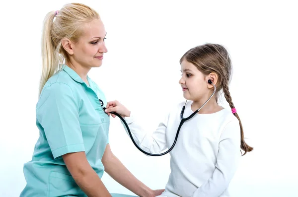 El médico juega con la niña-paciente, dejándola escucharse a sí misma con un fonendoscopio . — Foto de Stock