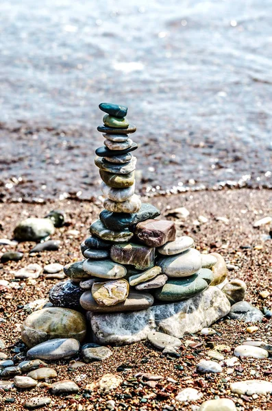 Pyramid of small colored stones on the coast. — Stock Photo, Image