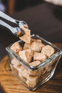 Bir parça küçük gümüş şekerlemeler cımbız, kahverengi şeker.