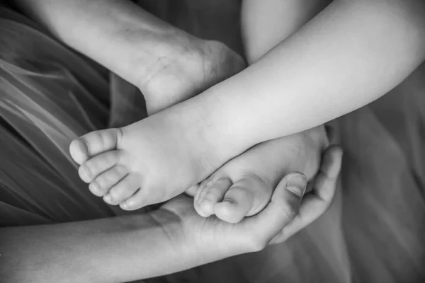 Yeni Doğmuş Bir Bebeğin Küçük Bacakları Bir Kız Kardeşin Ellerinde — Stok fotoğraf