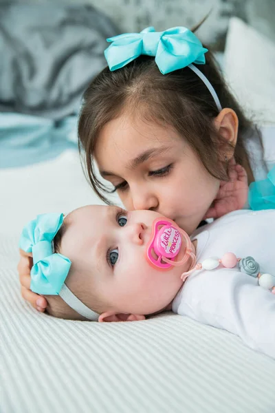 Девушка Целует Свою Новорожденную Сестру — стоковое фото