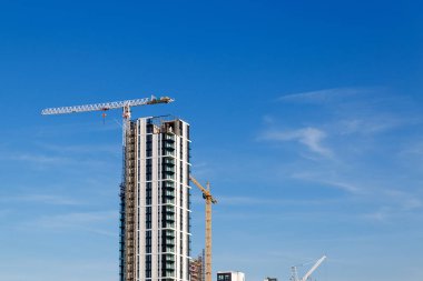 mavi gökyüzünün altında vinç ve inşaat site bina.