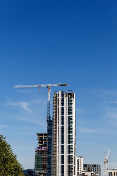 Mavi gökyüzünün altında vinç ve inşaat site bina. — Stok fotoğraf