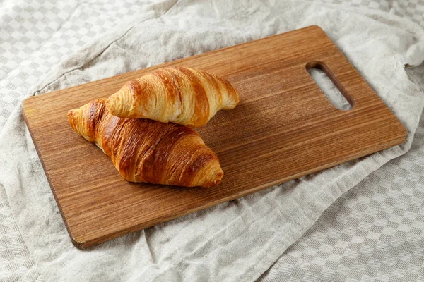 Delicious francuski świeżo upieczone rogaliki na pokładzie cięcia drewnianych. — Zdjęcie stockowe