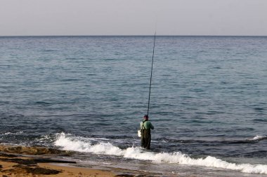 İsrail Akdeniz'in kıyısında oturan adam 