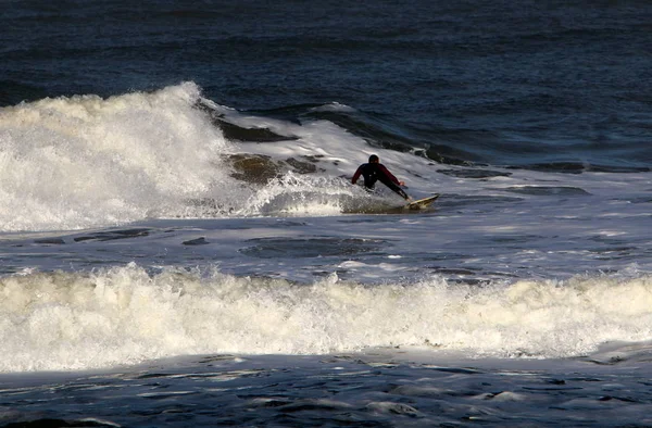 イスラエル共和国の北の地中海でサーフィン 光の波に乗ってボードします — ストック写真