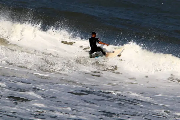 イスラエル共和国の北の地中海でサーフィン 光の波に乗ってボードします — ストック写真
