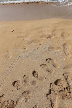 Akdeniz 'in kıyılarında, kuma ayak izleri 