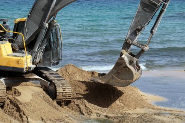 Akdeniz kıyısında büyük bir ekskavatör kazma kum mu 