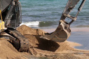 Akdeniz kıyısında büyük bir ekskavatör kazma kum mu 