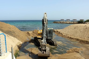 Akdeniz kıyısında büyük bir ekskavatör kazma kum mu 