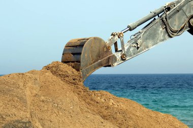 Akdeniz kıyısında büyük bir ekskavatör kazma kum mu 