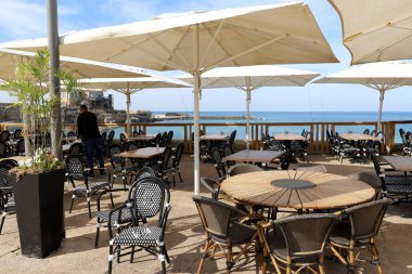 İsrail 'de Akdeniz kıyısındaki bir kafede bir sandalye ve masa duruyor. 