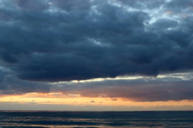 Kuzey İsrail'de Akdeniz'de ufukta güneş batıyor, gündüz bitiyor ve gece çöküyor 