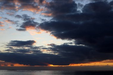 Kuzey İsrail'de Akdeniz'de ufukta güneş batıyor, gündüz bitiyor ve gece çöküyor 