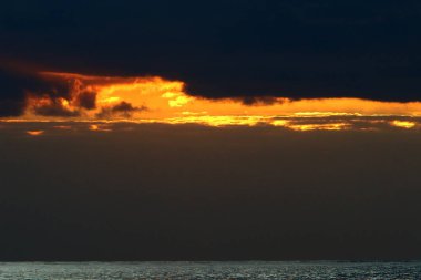Kuzey İsrail'de Akdeniz'de ufukta güneş batıyor, gündüz bitiyor ve gece çöküyor 