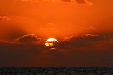 Kuzey İsrail'de Akdeniz'de ufukta güneş batıyor, gündüz bitiyor ve gece çöküyor 