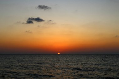 Kuzey İsrail'de Akdeniz'de ufukta güneş batıyor, gündüz bitiyor ve gece çöküyor 