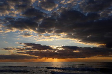 Kuzey İsrail'de Akdeniz'de ufukta güneş batıyor, gündüz bitiyor ve gece çöküyor 