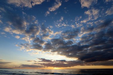 Kuzey İsrail'de Akdeniz'de ufukta güneş batıyor, gündüz bitiyor ve gece çöküyor 