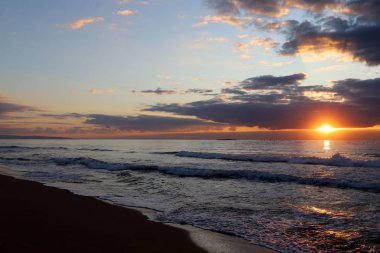 Kuzey İsrail'de Akdeniz'de ufukta güneş batıyor, gündüz bitiyor ve gece çöküyor 