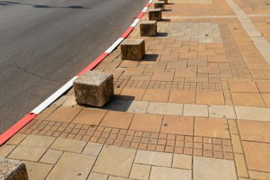 İsrail 'in büyük bir şehrinde kaldırımda duran çok renkli beton figürler, yayalar için bir bariyer görevi görüyor. 