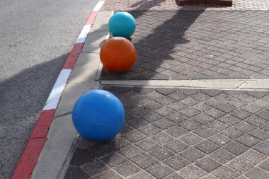 İsrail 'in büyük bir şehrinde kaldırımda duran çok renkli beton figürler, yayalar için bir bariyer görevi görüyor. 