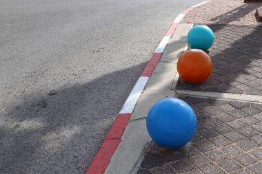 İsrail 'in büyük bir şehrinde kaldırımda duran çok renkli beton figürler, yayalar için bir bariyer görevi görüyor. 