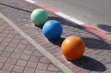 İsrail 'in büyük bir şehrinde kaldırımda duran çok renkli beton figürler, yayalar için bir bariyer görevi görüyor. 