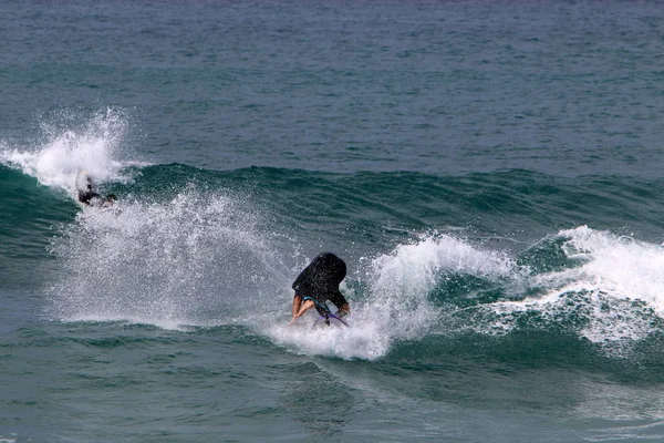 イスラエル北部の地中海での嵐の間の大きな波でサーフィン — ストック写真