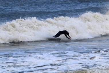 İsrail 'in kuzeyindeki Akdeniz' de büyük dalgalarda özel sörf tahtalarına binmek 